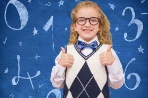 Digital composition of smiling girl showing thumbs up against mathematical background